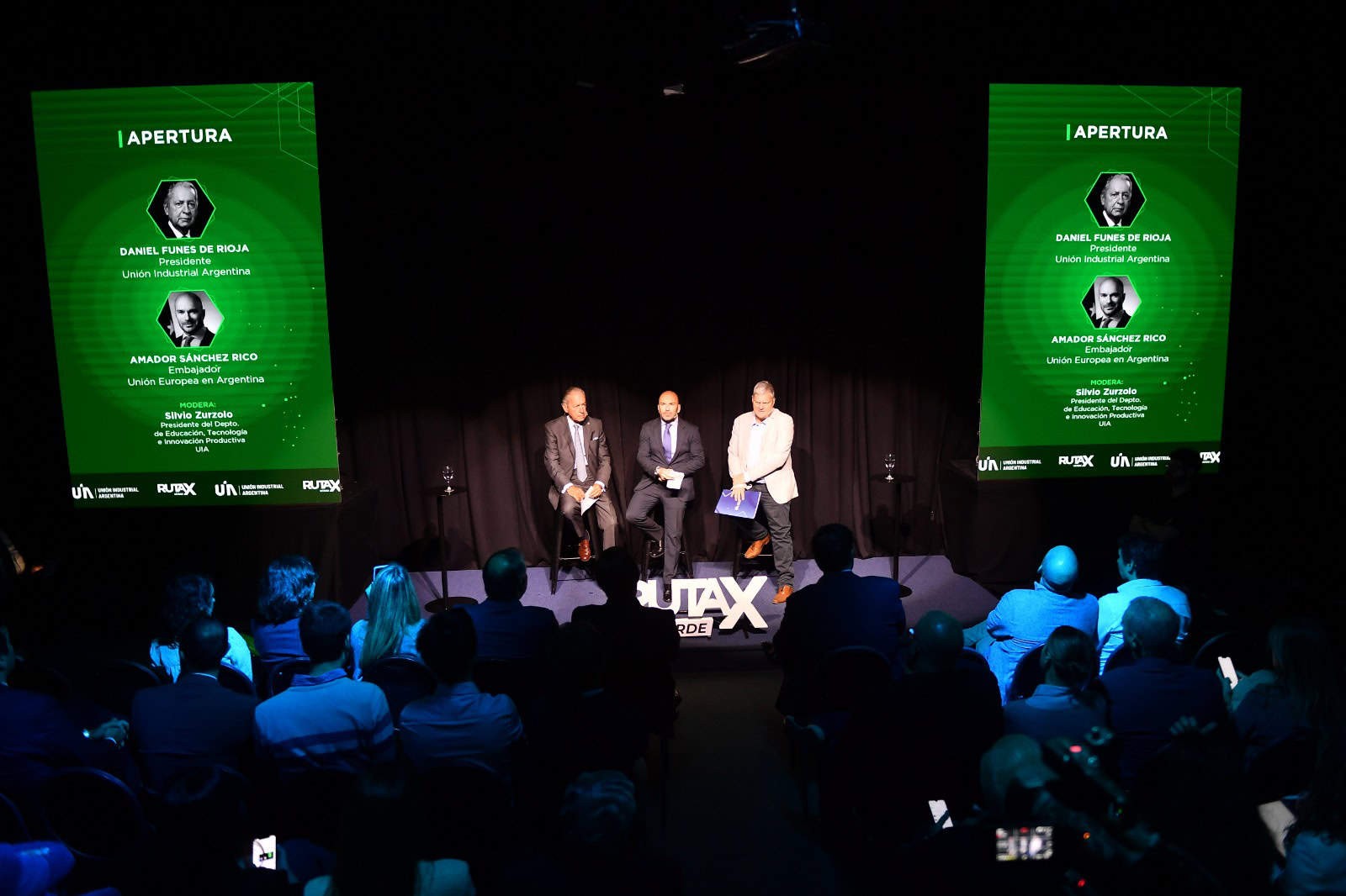 A group of men sitting on stools on stage at the Ruta X Verde sustainability course 2024 launch event