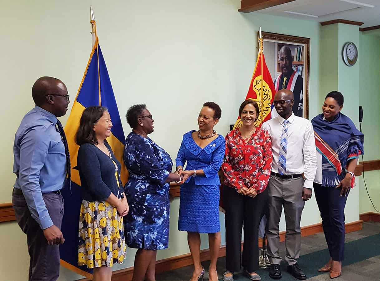 Group of people smiling and shaking hands in Barbados