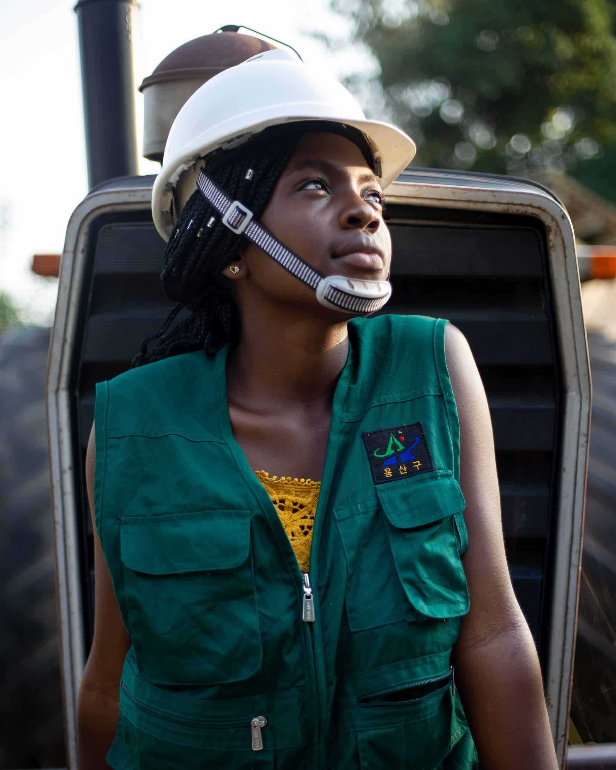 Woman in green jacket wearing white cap and headphones