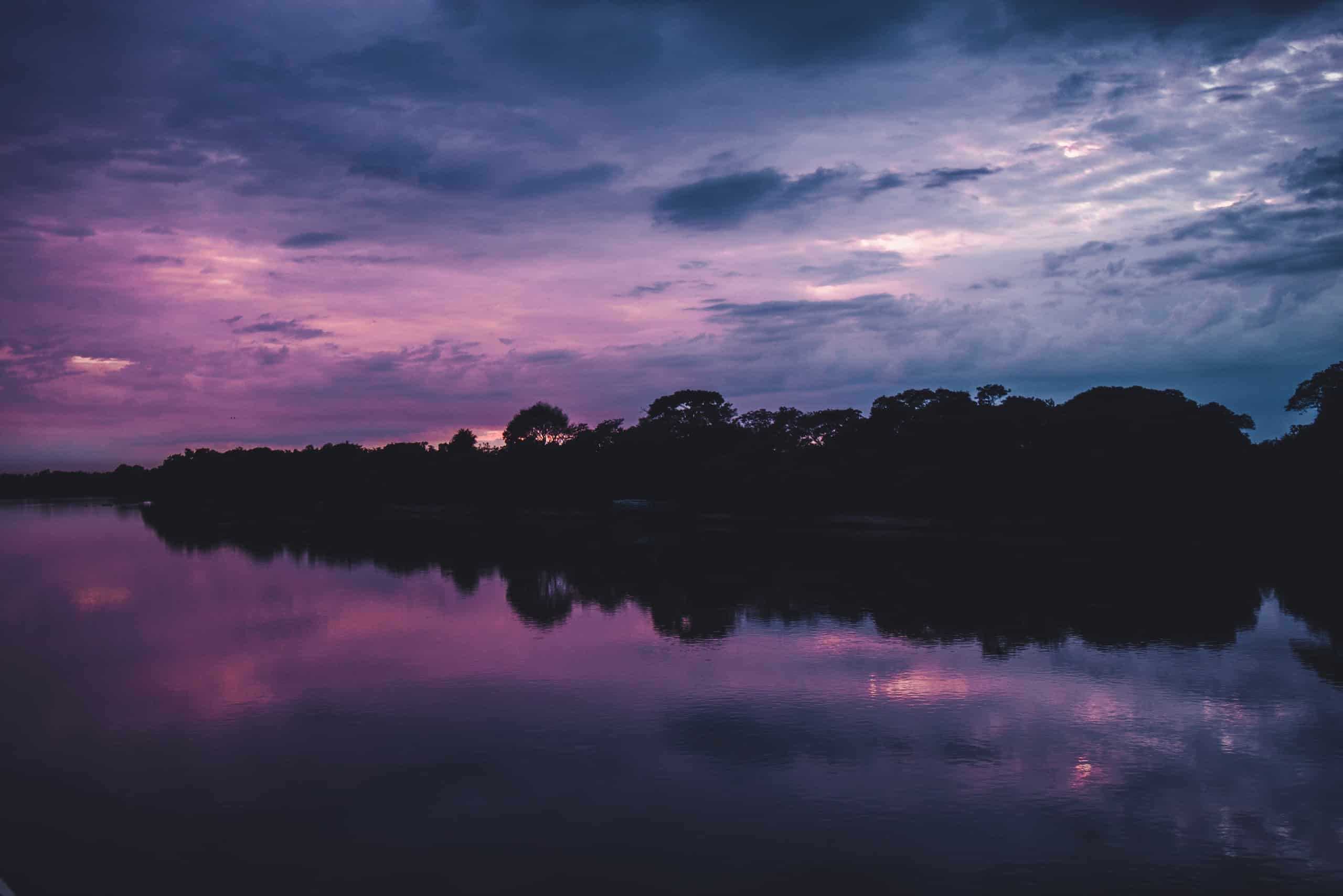 Cloudy purple and blue sunset reflected into water in Mato Grosso, Brazil