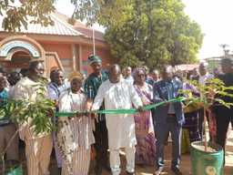 A group of people cutting a green ribbon