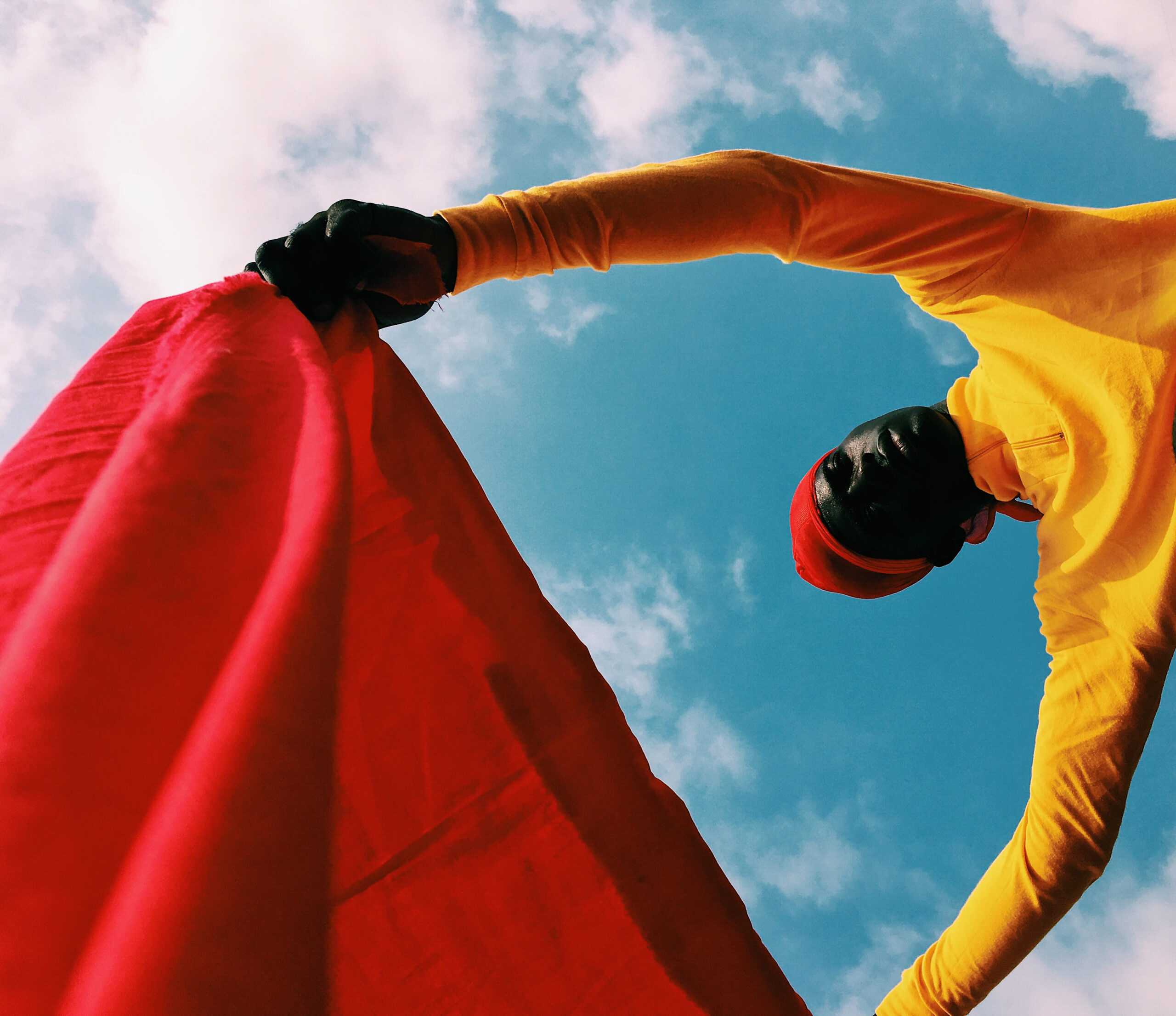 A person in a yellow shirt holding a red cloth