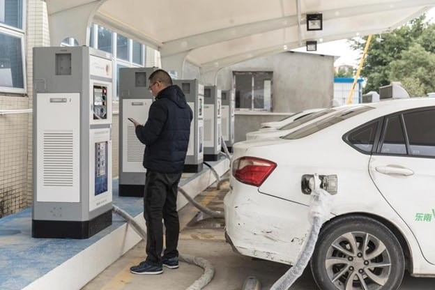 Man electrically charging car