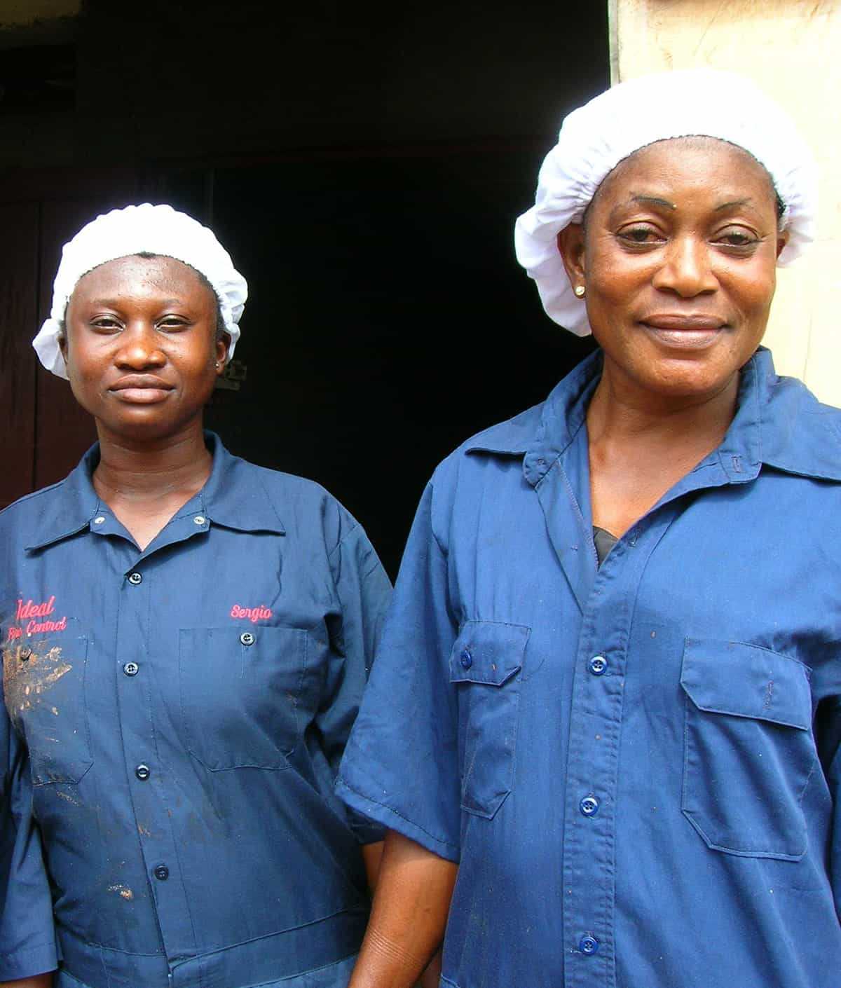 Two smiling women wearing hairnets in Ghana