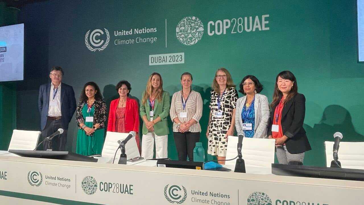 A group of women standing in front of a green wall