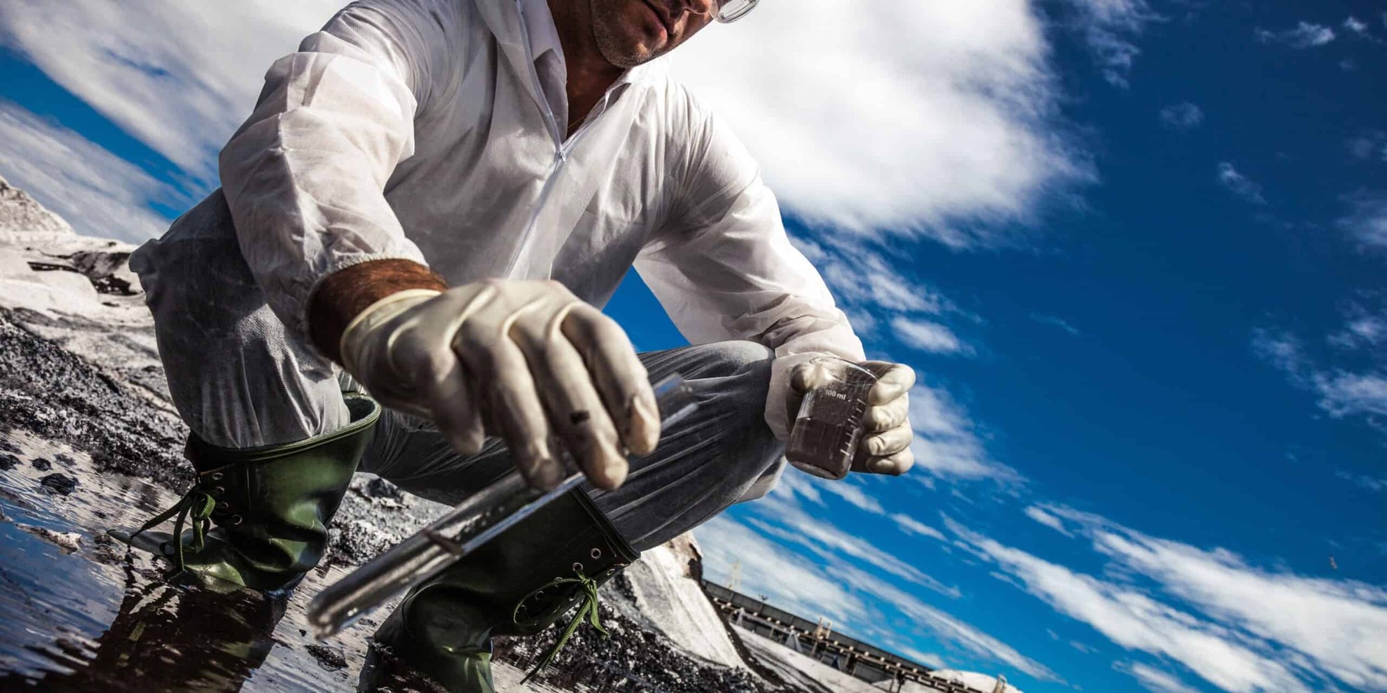 a scientists taking a sample of water from a river